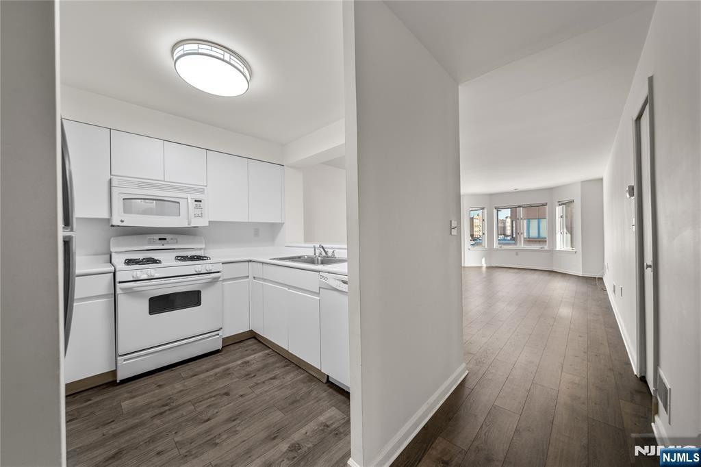 a kitchen with wooden floors and white appliances