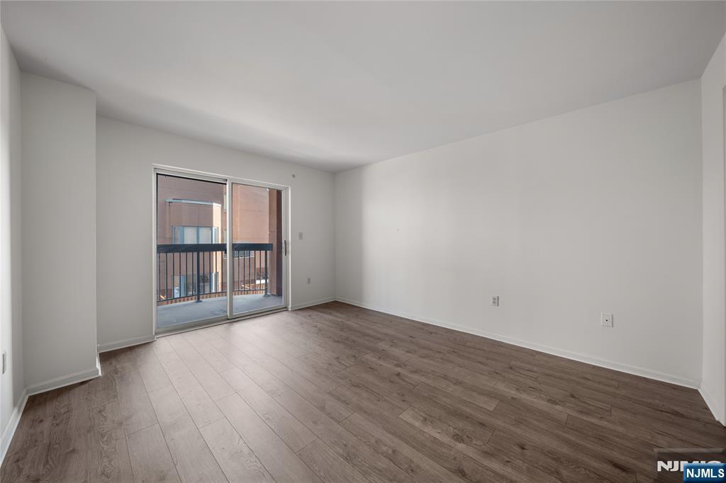 402 Chase Court, Unit 402 Edgewater, NJ 07020 - Photo 13 of 21 a view of an empty room with wooden floor and a window