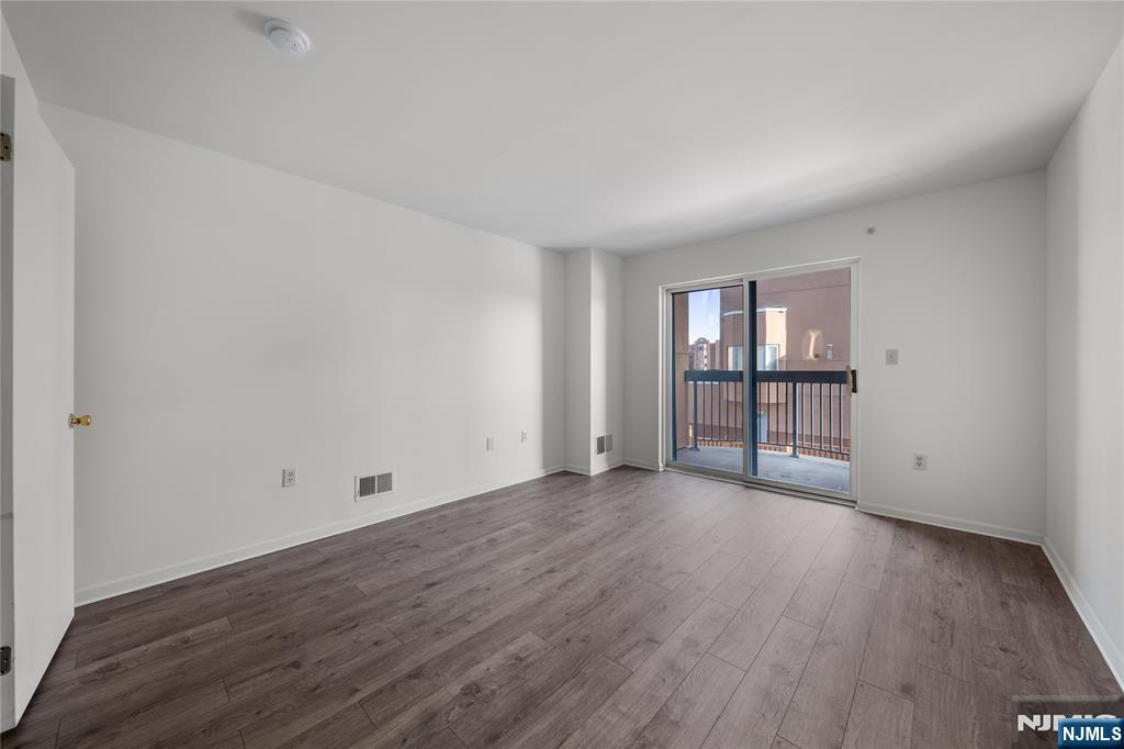402 Chase Court, Unit 402 Edgewater, NJ 07020 - Photo 14 of 21 an empty room with wooden floor and windows