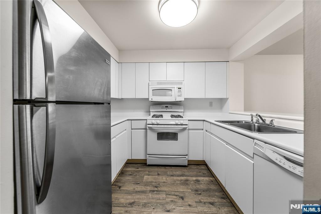 402 Chase Court, Unit 402 Edgewater, NJ 07020 - Photo 3 of 21 a kitchen with a white cabinets and white appliances