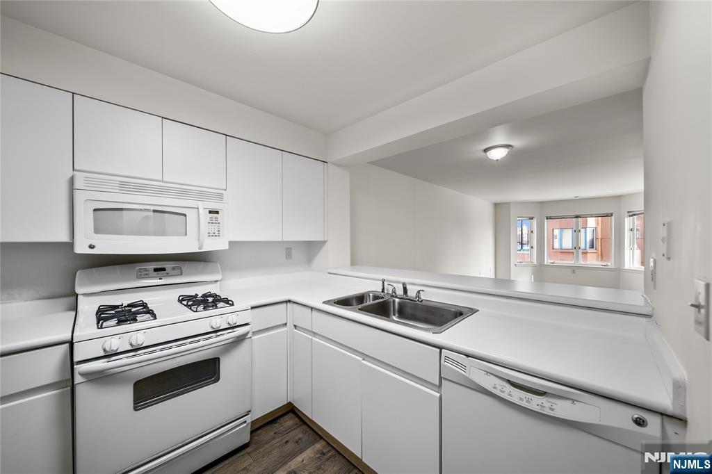 402 Chase Court, Unit 402 Edgewater, NJ 07020 - Photo 4 of 21 a kitchen with granite countertop a sink and a stove top oven