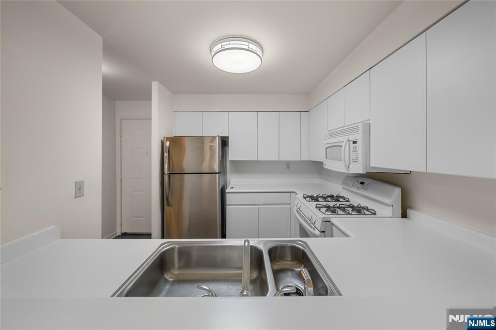402 Chase Court, Unit 402 Edgewater, NJ 07020 - Photo 5 of 21 a kitchen with stainless steel appliances granite countertop a sink a refrigerator and a stove