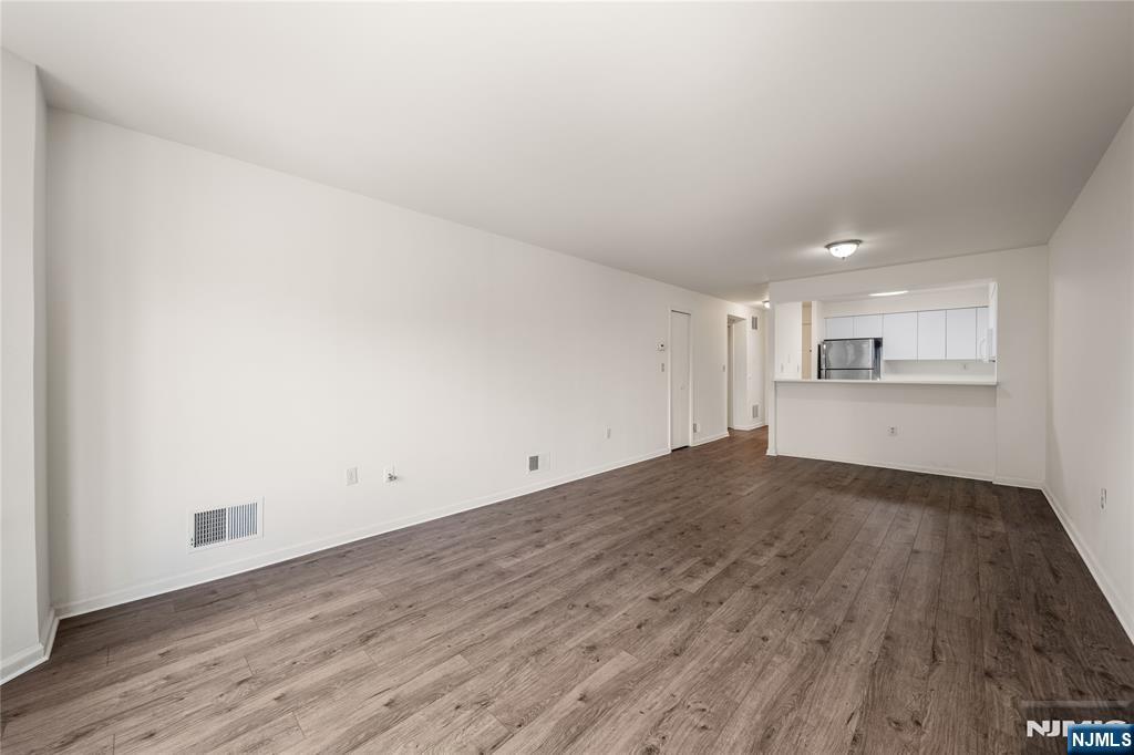 402 Chase Court, Unit 402 Edgewater, NJ 07020 - Photo 9 of 21 an empty room with wooden floor and windows