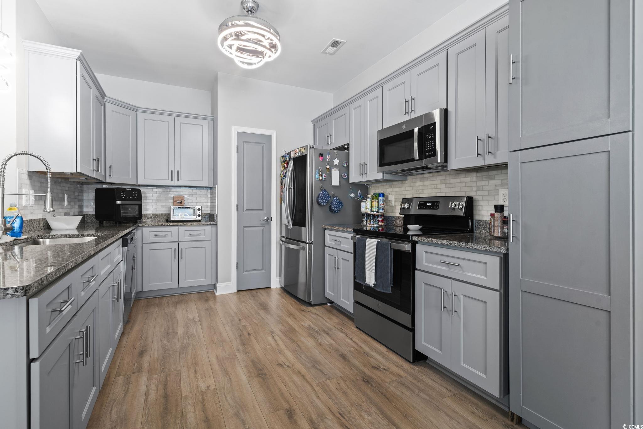 804 Twickenham Loop Longs, SC 29568 - Photo 11 of 26 Kitchen with gray cabinets, stainless steel appliances, dark stone countertops, and backsplash