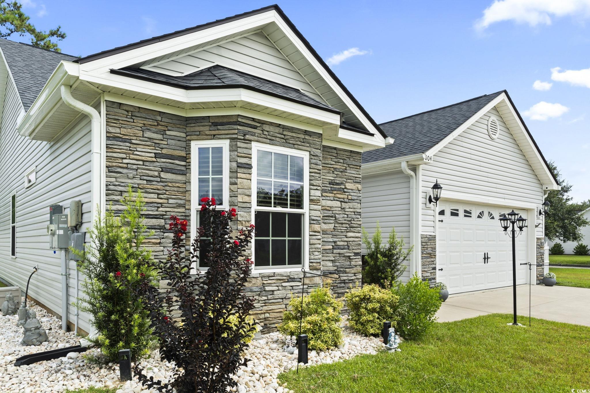 804 Twickenham Loop Longs, SC 29568 - Photo 3 of 26 View of front of home featuring stone siding, concrete driveway, a garage, and roof with shingles