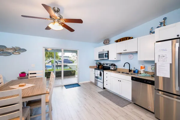 a kitchen with stainless steel appliances a stove a sink dishwasher and a refrigerator with wooden floor