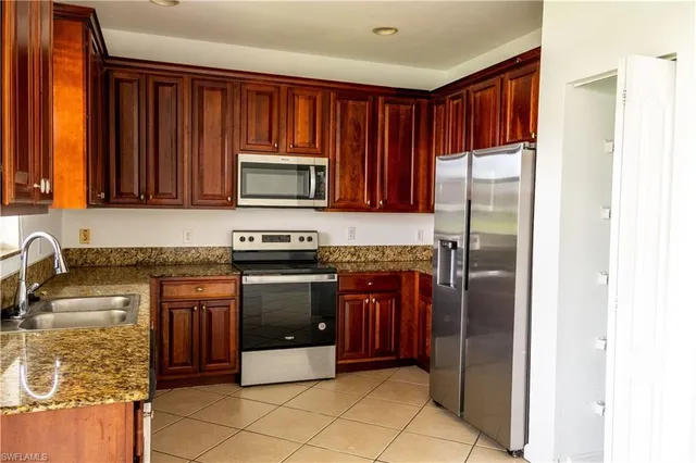 a kitchen with stainless steel appliances granite countertop a refrigerator and a stove top oven