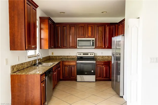 a kitchen with stainless steel appliances granite countertop a refrigerator stove and sink