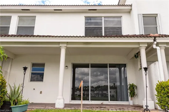 a front view of a house with swimming pool and glass windows