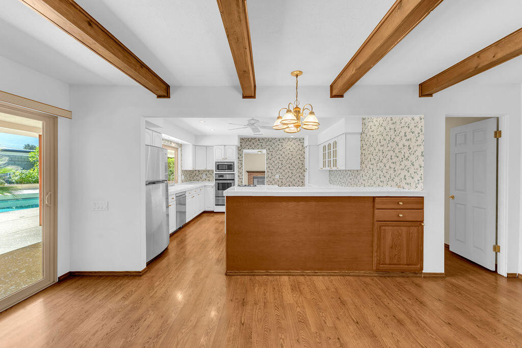 74075 Setting Sun Trail Palm Desert, CA 92260 - Photo 13 of 52 a view of a kitchen with granite countertop cabinets and wooden floor