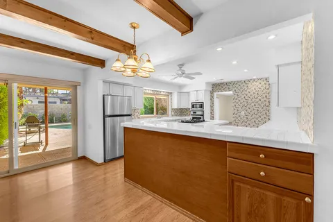 a kitchen with a sink a stove cabinets and wooden floor