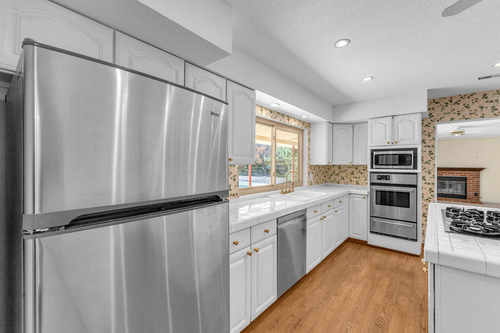 74075 Setting Sun Trail Palm Desert, CA 92260 - Photo 15 of 52 a kitchen with stainless steel appliances a refrigerator sink and microwave