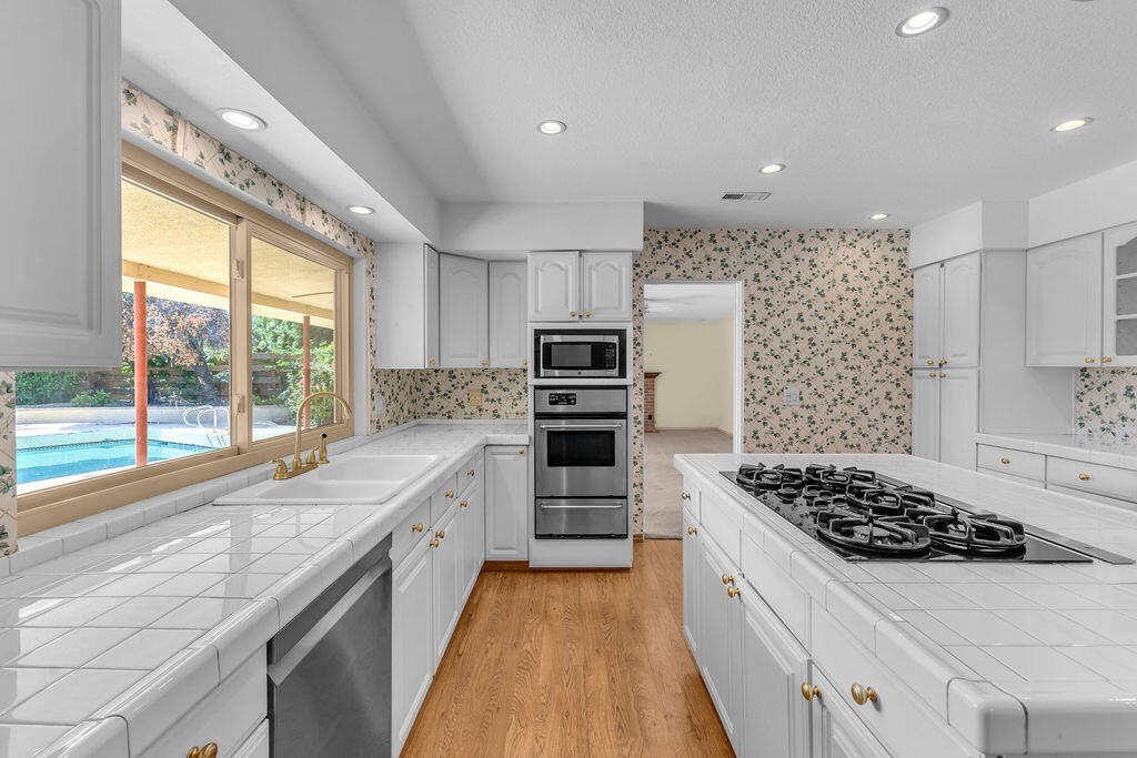 74075 Setting Sun Trail Palm Desert, CA 92260 - Photo 16 of 52 a kitchen with stainless steel appliances kitchen island granite countertop a stove and a sink