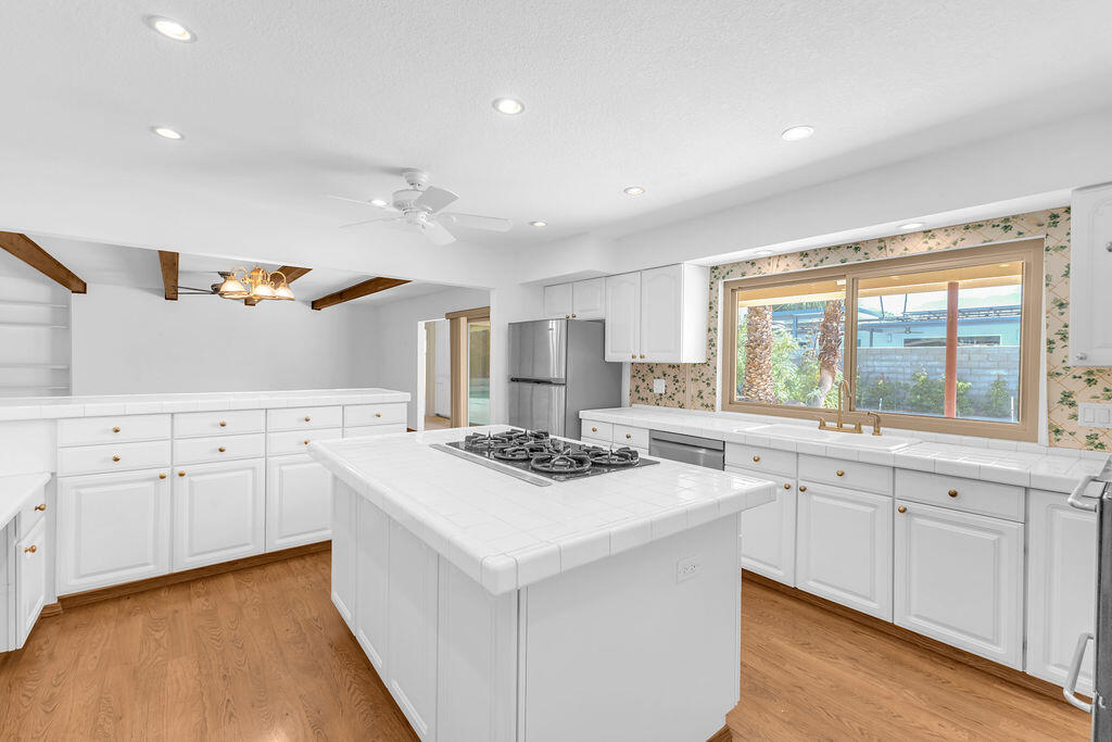 74075 Setting Sun Trail Palm Desert, CA 92260 - Photo 18 of 52 a kitchen with white cabinets and window
