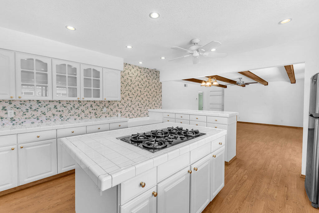 74075 Setting Sun Trail Palm Desert, CA 92260 - Photo 19 of 52 a kitchen with a sink a stove cabinets and wooden floor
