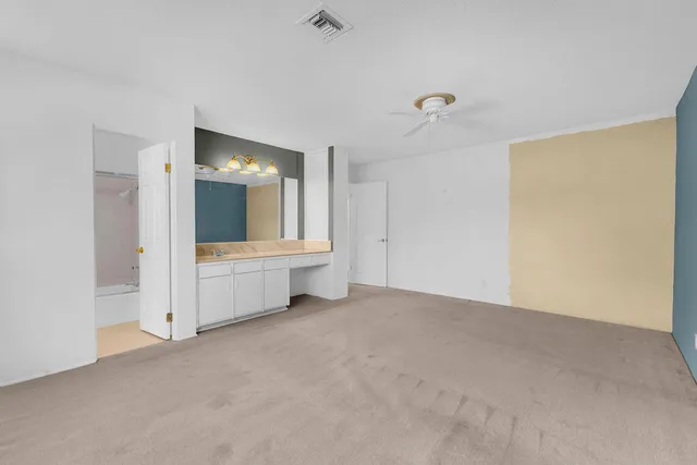 a view of a room with large mirror and window