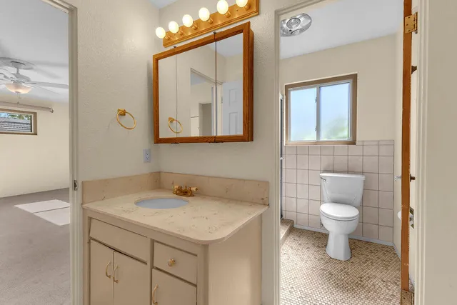 a bathroom with a toilet sink and mirror