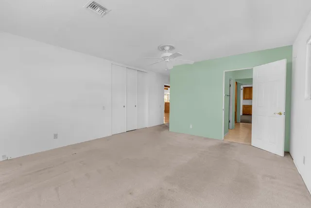 an empty room with an entryway and closet area
