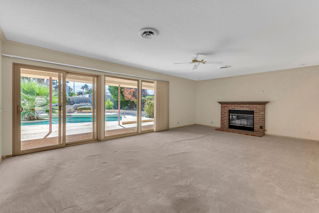 74075 Setting Sun Trail Palm Desert, CA 92260 - Photo 6 of 52 a view of an empty room with a fireplace and a window