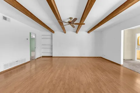 a view of empty room with wooden floor and stairs