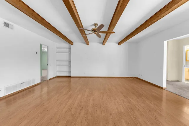 an empty room with wooden floor and door
