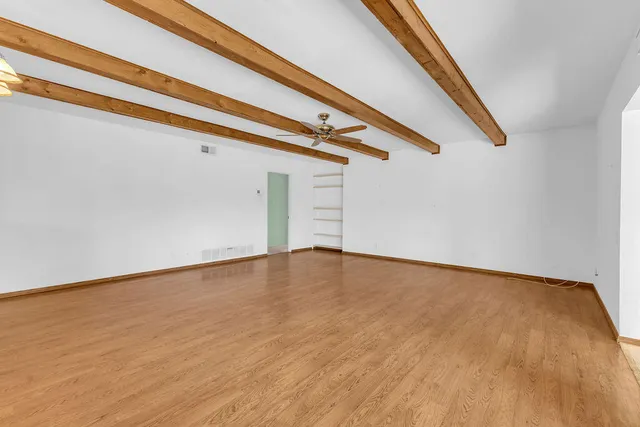 a view of empty room with wooden floor and stairs