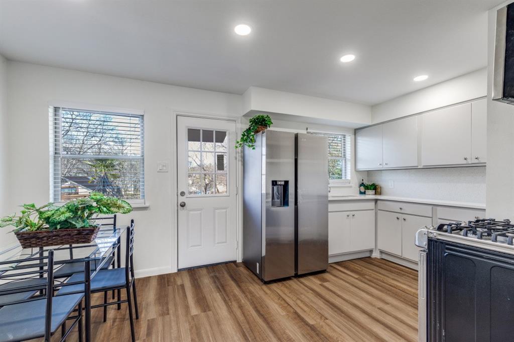 2663 Springvale Drive Farmers Branch, TX 75234 - Photo 15 of 25 a kitchen with stainless steel appliances a refrigerator a stove a sink and white cabinets with wooden floor