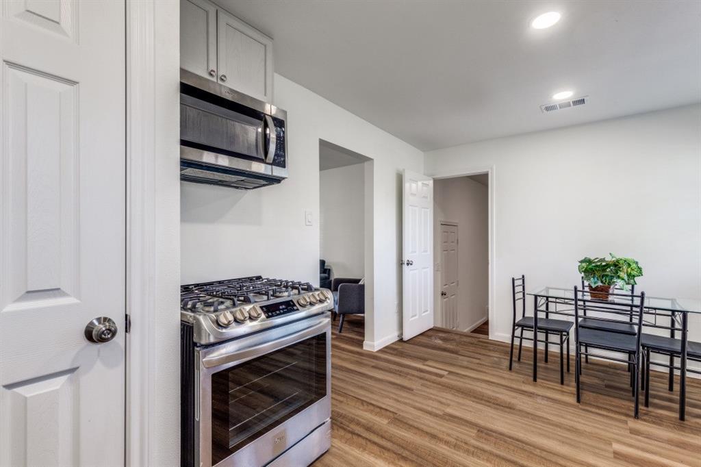2663 Springvale Drive Farmers Branch, TX 75234 - Photo 9 of 25 a kitchen with stainless steel appliances a stove a microwave and white cabinets