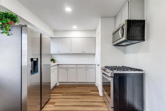 a kitchen with stainless steel appliances granite countertop a stove microwave and refrigerator