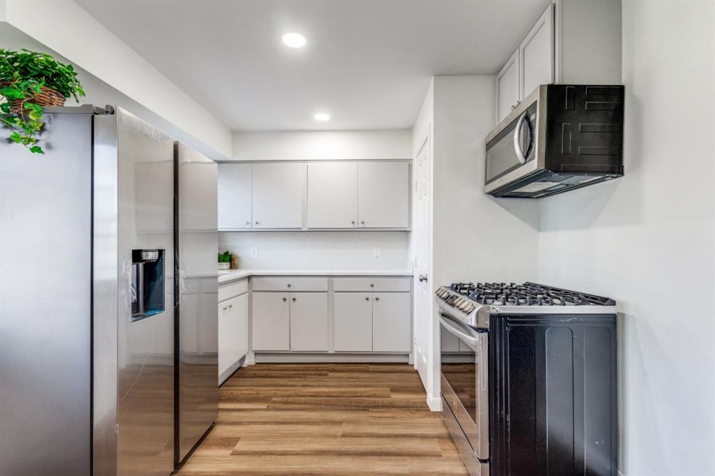 2663 Springvale Drive Farmers Branch, TX 75234 - Photo 10 of 25 a kitchen with stainless steel appliances granite countertop a stove microwave and refrigerator
