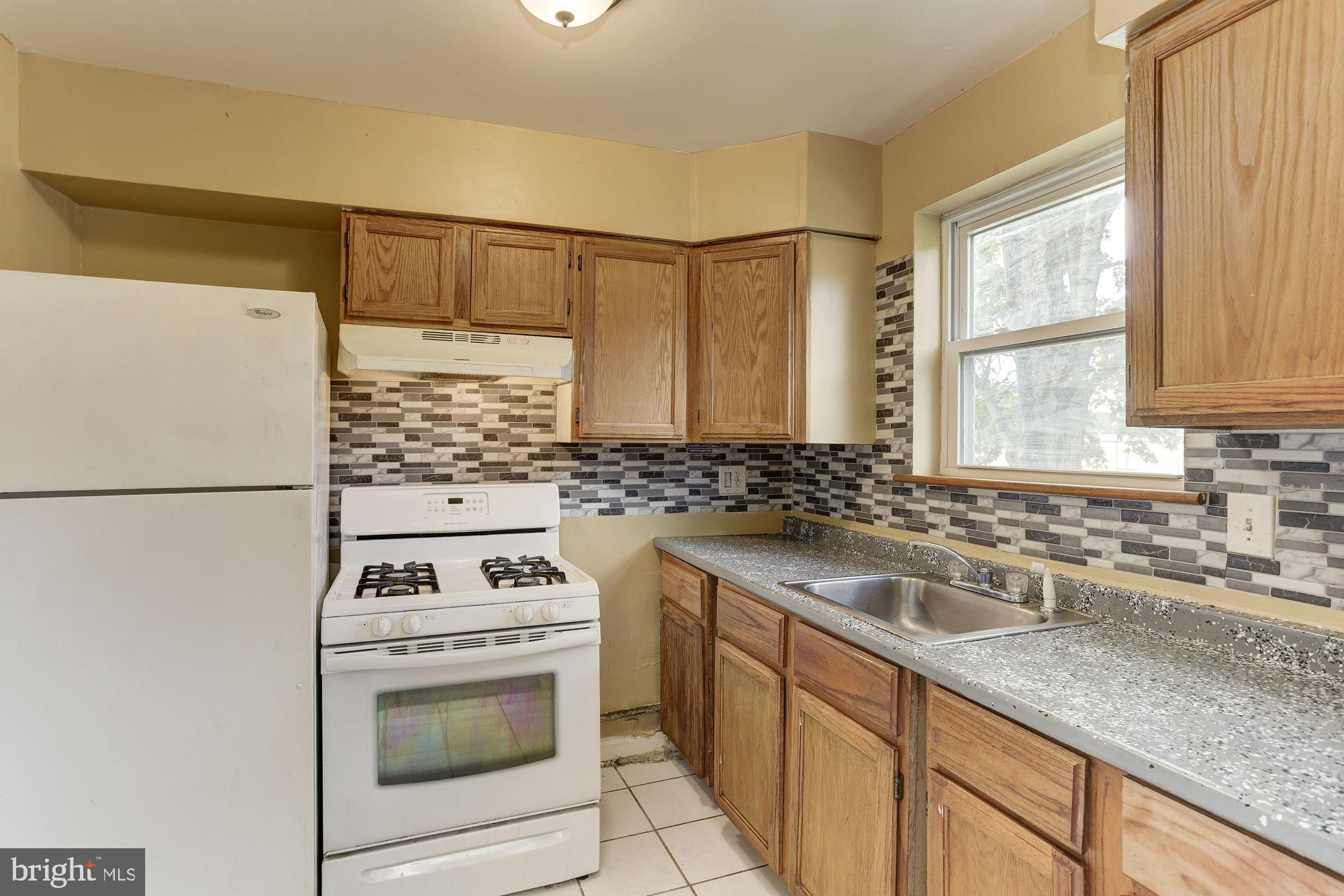 1925 Addison Road South District Heights, MD 20747 - Photo 6 of 9 a kitchen with granite countertop a sink cabinets stainless steel appliances and a counter space