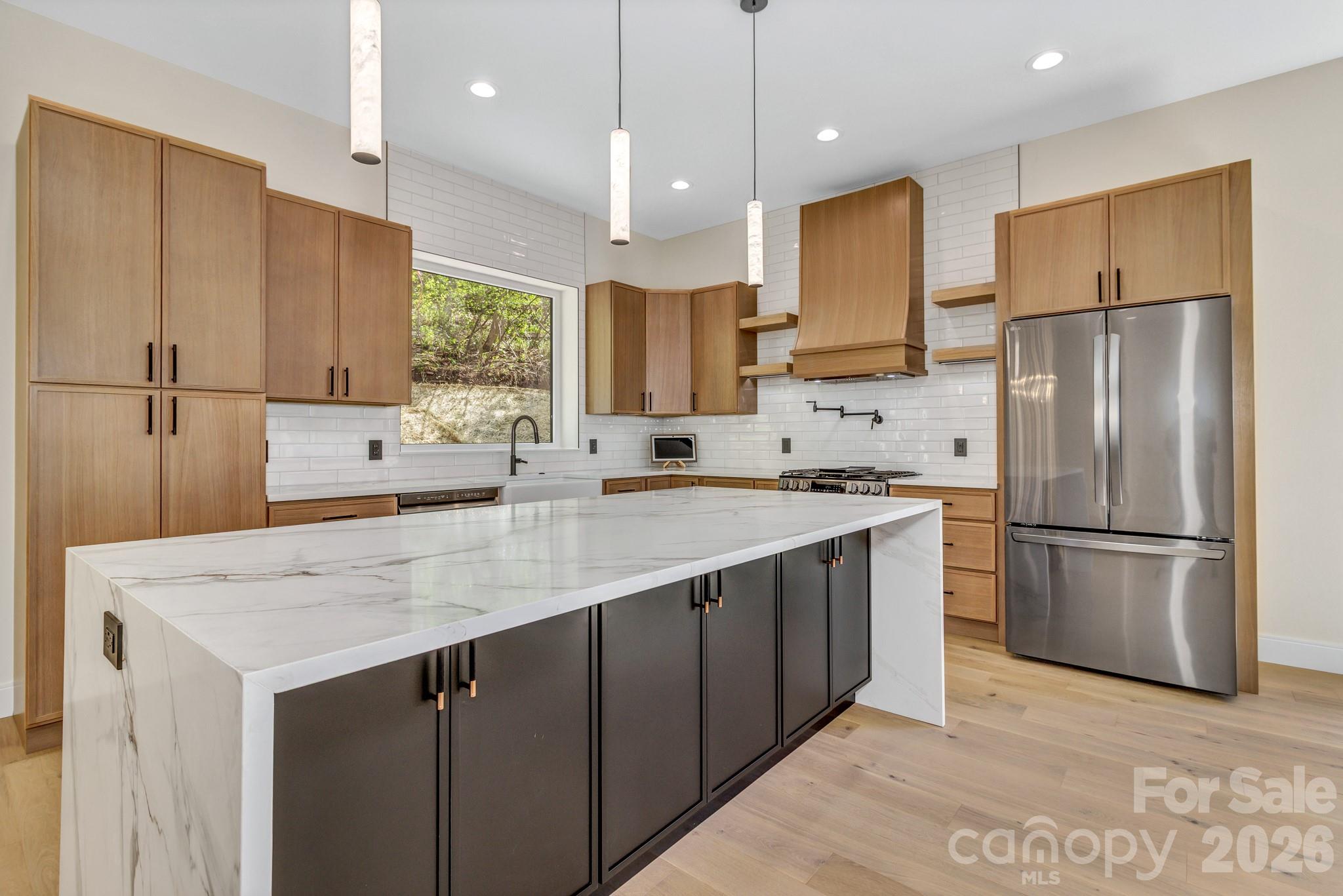 134 View Ridge Parkway Leicester, NC 28748 - Photo 11 of 48 a kitchen with kitchen island a sink stainless steel appliances and refrigerator
