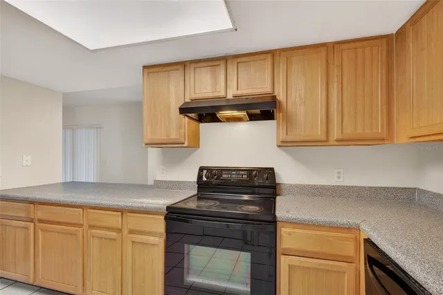 a kitchen with granite countertop cabinets stove top oven and sink