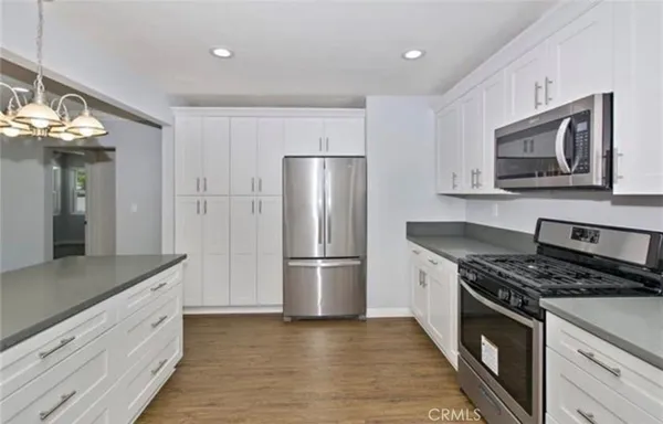 a kitchen with stainless steel appliances granite countertop a refrigerator stove and microwave