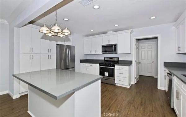 a kitchen with stainless steel appliances a refrigerator sink and microwave