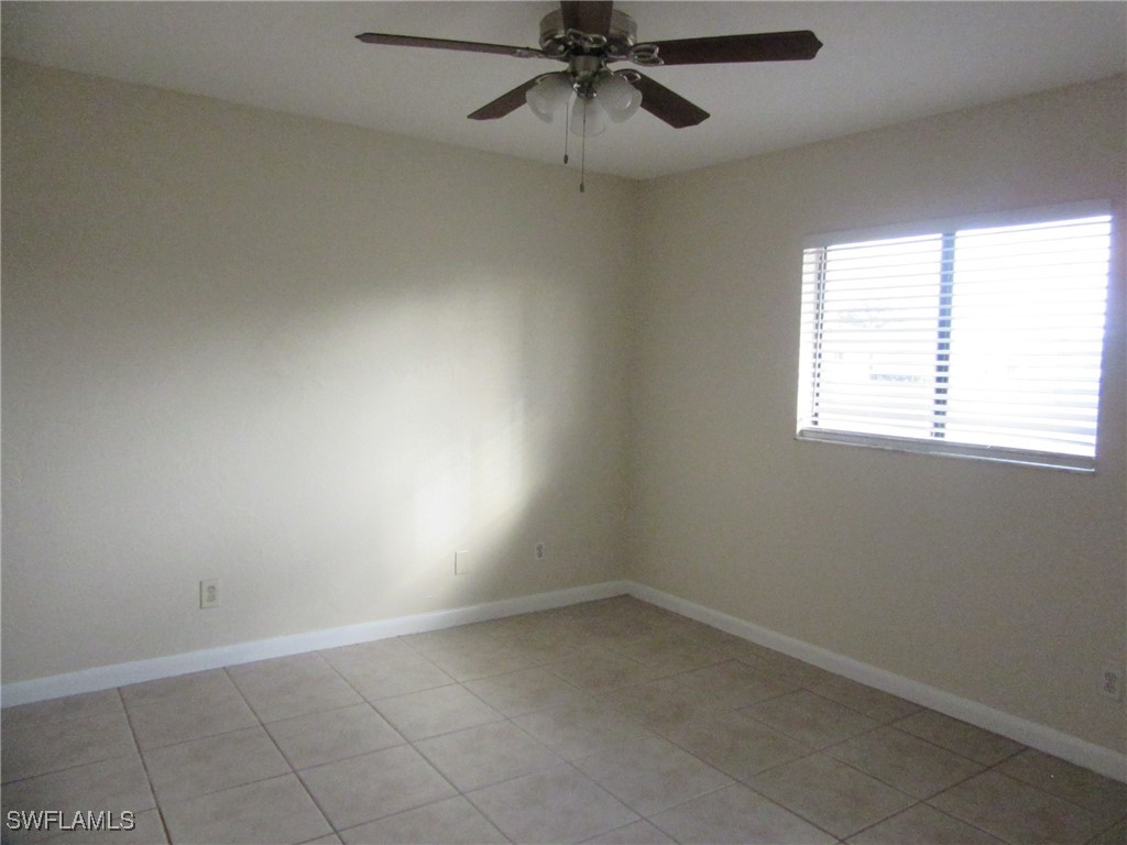 3215 Skyline Boulevard, Unit C Cape Coral, FL 33914 - Photo 13 of 25 an empty room with a window and a fan