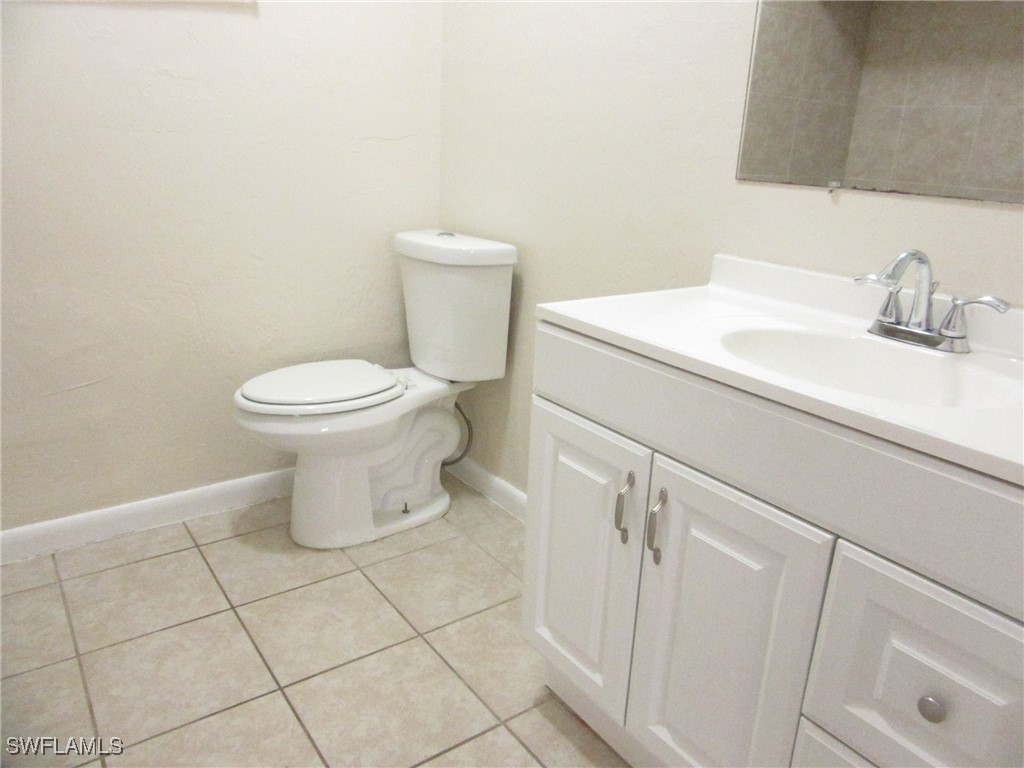 3215 Skyline Boulevard, Unit C Cape Coral, FL 33914 - Photo 16 of 25 a white toilet sitting next to a bathroom sink