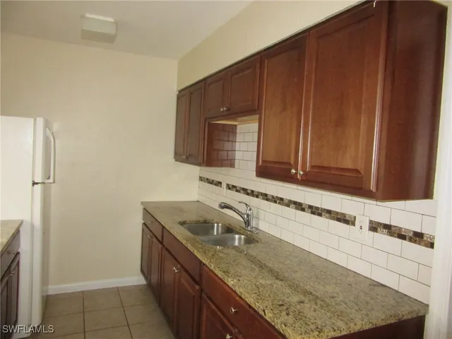 a kitchen with granite countertop a sink stove and cabinets