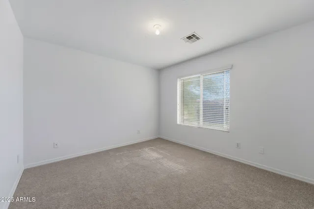 a view of a chair and table in backyard of the house