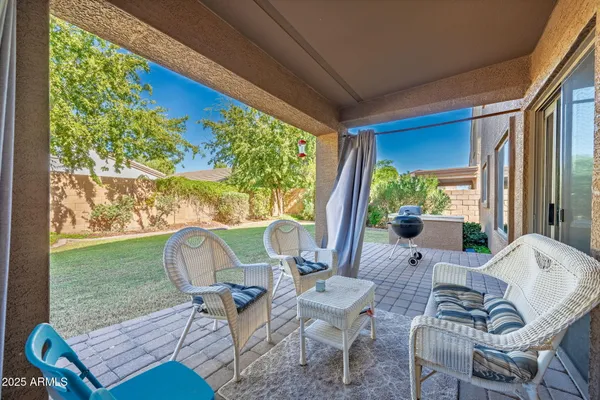 a view of a house with a yard potted plants and a table