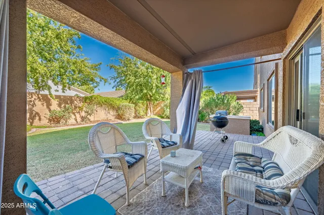 a view of a house with a yard potted plants and a table