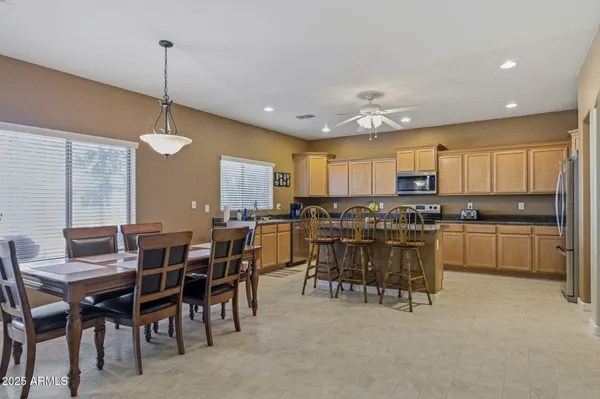 a large kitchen with kitchen island a dining table chairs and white cabinets