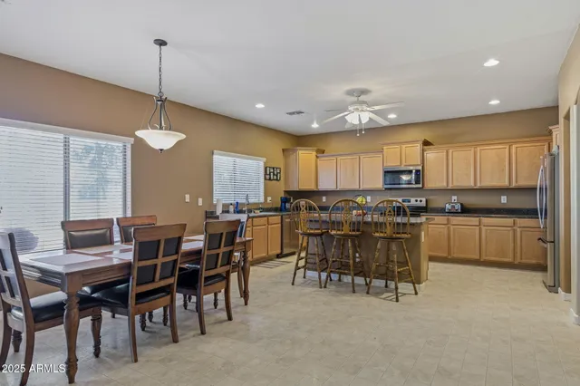 a large kitchen with kitchen island a dining table chairs and white cabinets