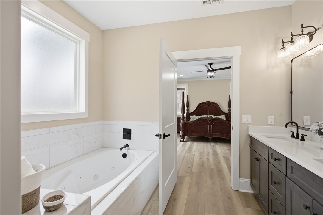 147 McAlister Road West Union, SC 29696 - Photo 16 of 49 This serene primary bathroom offers a relaxing soaking tub and dual vanity, conveniently adjacent to the bedroom.