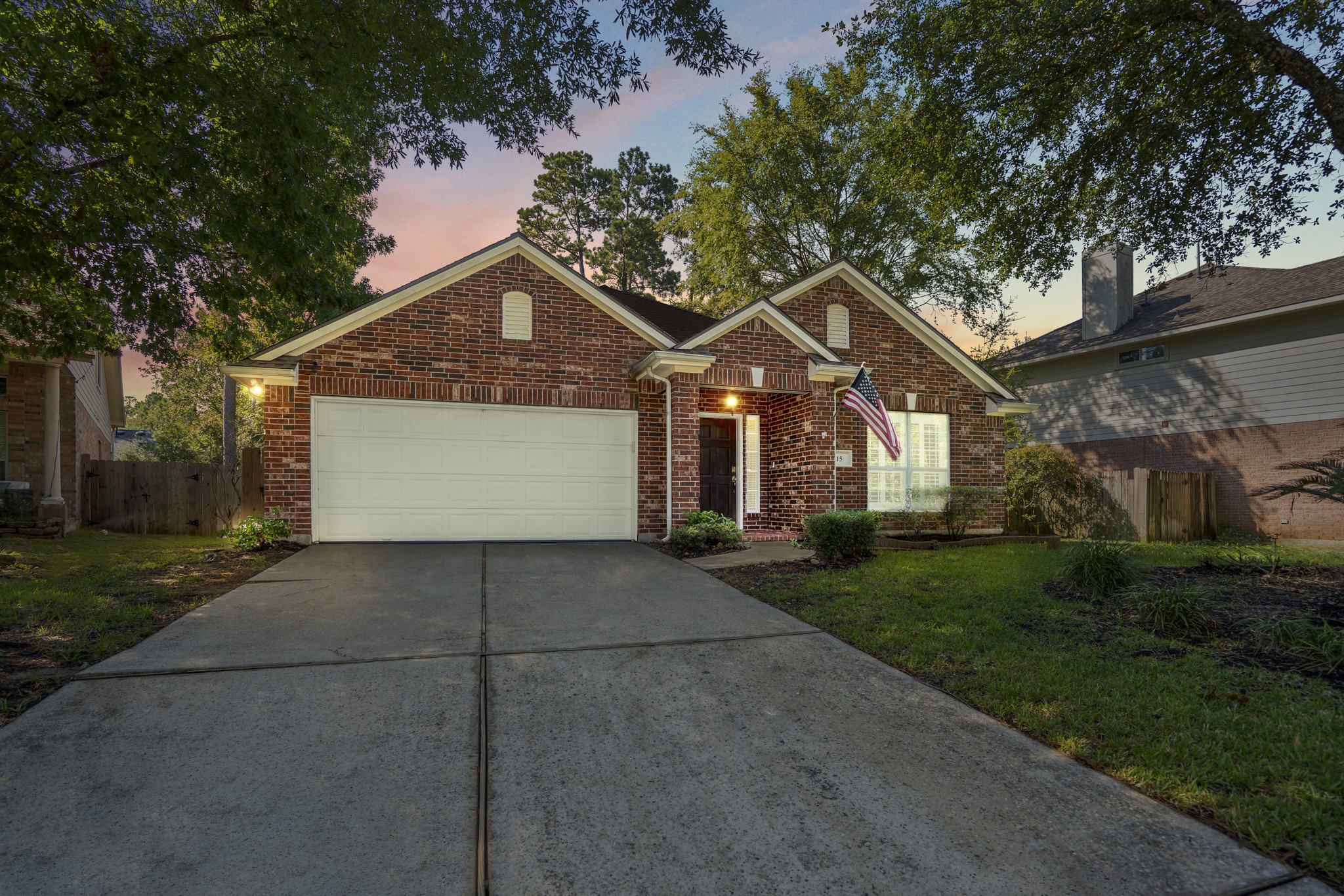 a front view of a house with a garden and trees