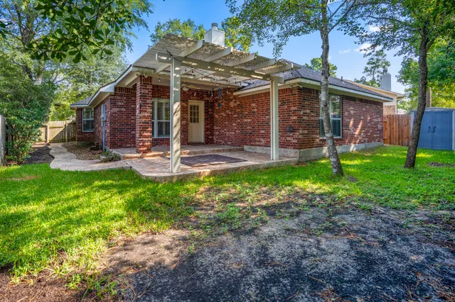 a view of a house with backyard and a tree