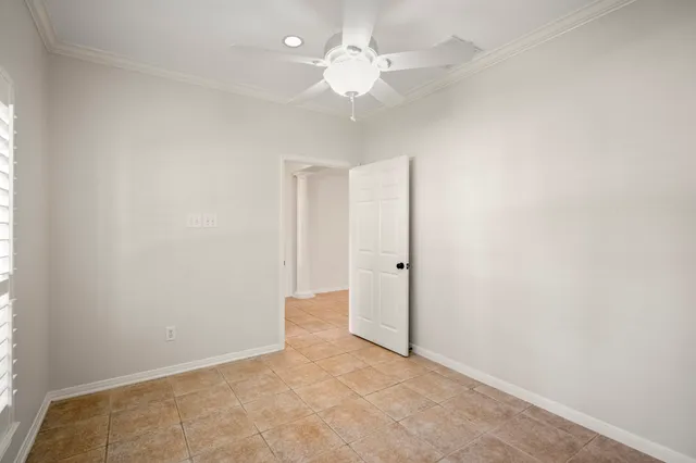 an empty room with a chandelier fan and closet