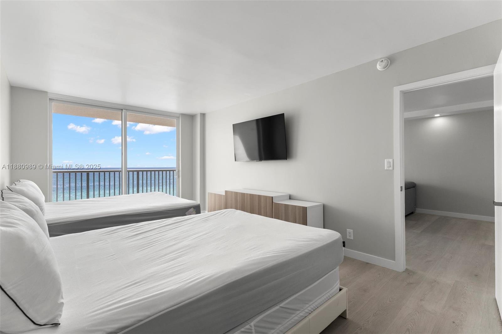 400 North Surf Road, Unit 903 Hollywood, FL 33019 - Photo 15 of 34 a bedroom with a balcony a bed and a flat screen tv