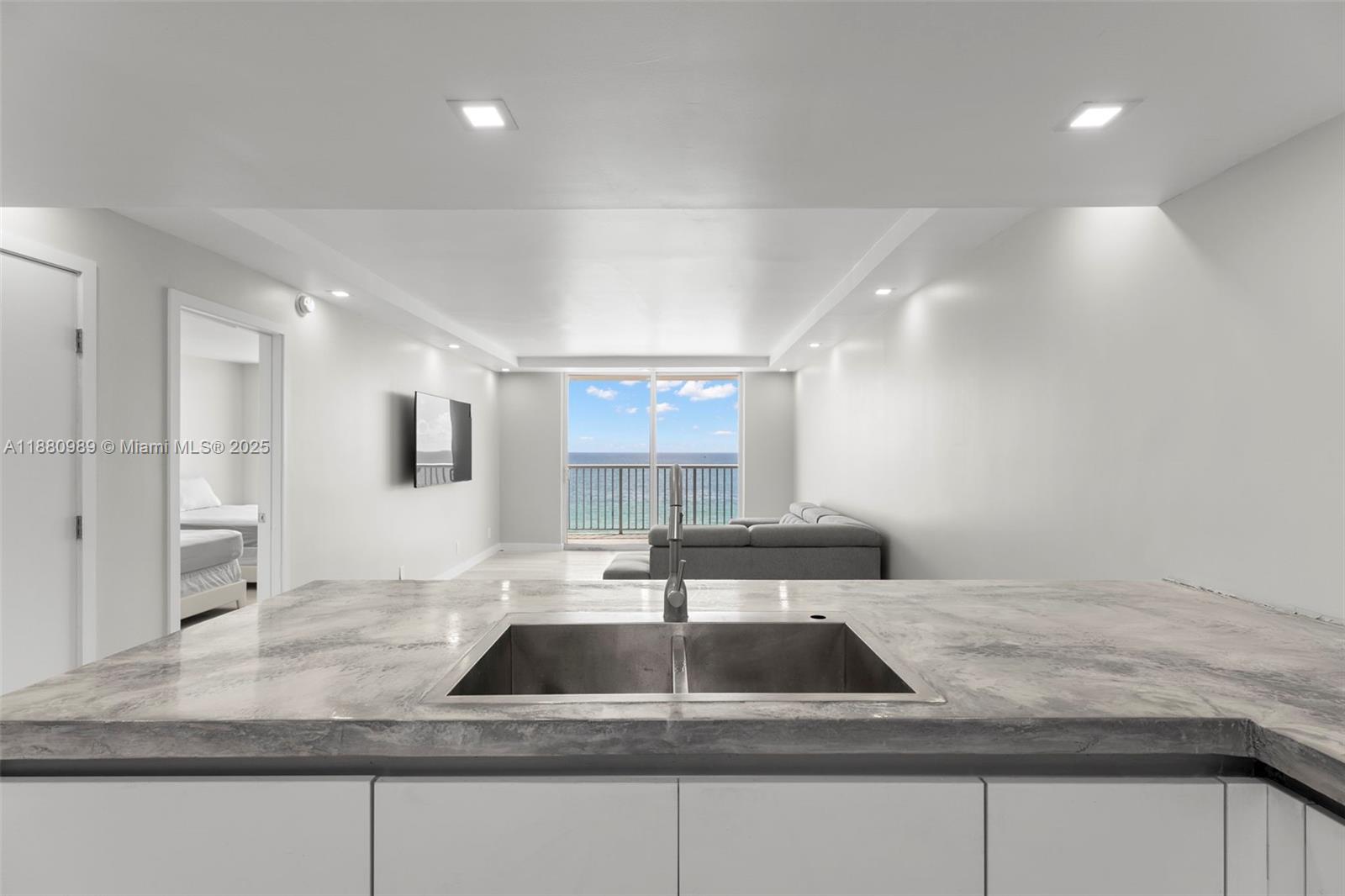 400 North Surf Road, Unit 903 Hollywood, FL 33019 - Photo 3 of 34 a kitchen with kitchen island a sink a counter and a refrigerator