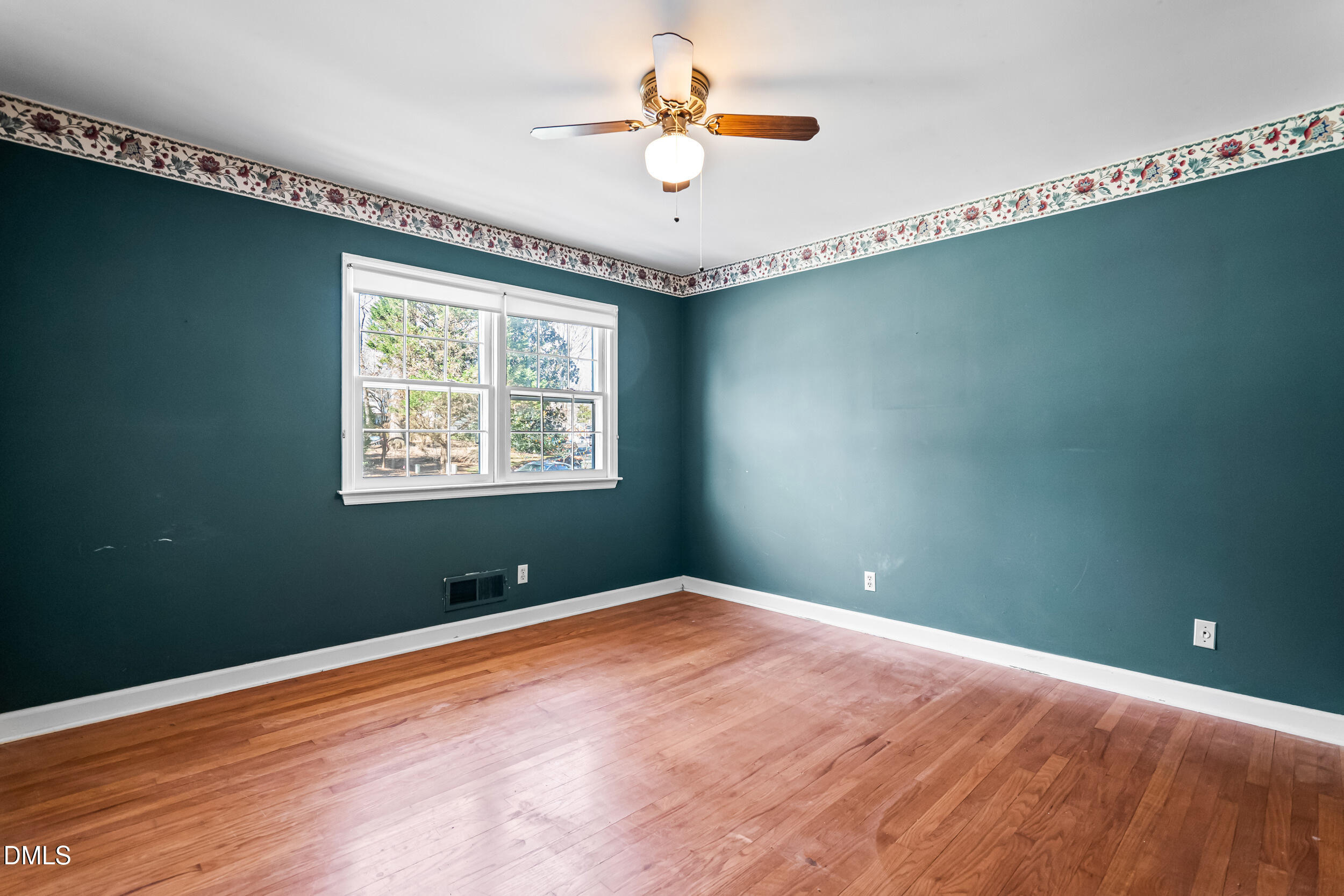 4208 Redington Drive Raleigh, NC 27609 - Photo 33 of 45 a view of a room with a large window a ceiling fan and wooden floor
